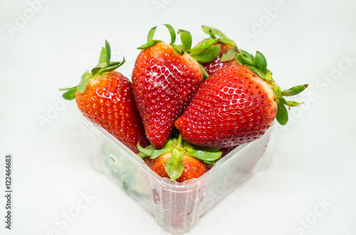 Group of fresh strawberries in plastics box, group of strawberries in white background