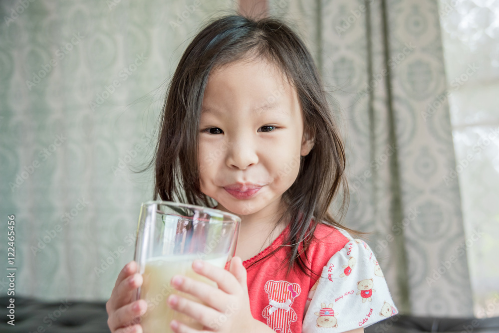 Little asian girl drinking milk from glass Little asian girl drinking milk from glass