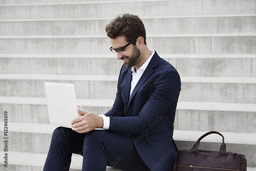 Businessman using laptop on steps Businessman using laptop on steps