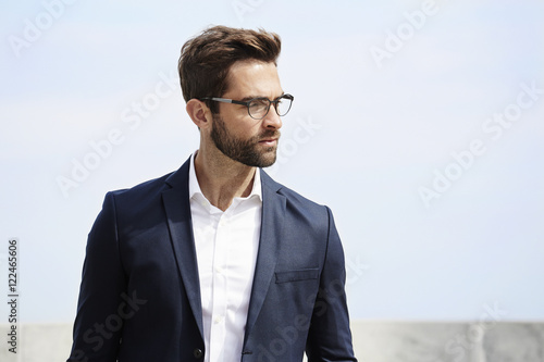 Bearded businessman looking away in spectacles