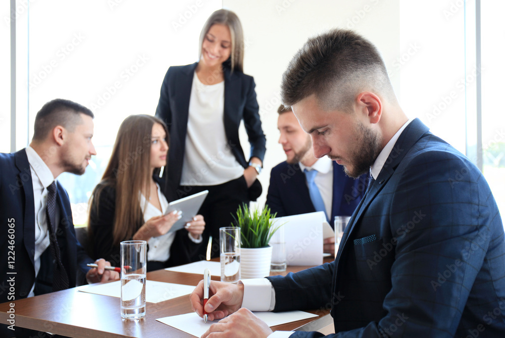 Businessman with colleagues in the background in office Businessman with colleagues in the background in office