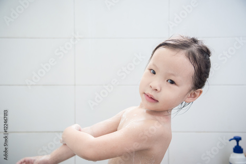 Little asian girl cleasing herself by soap in bathroom