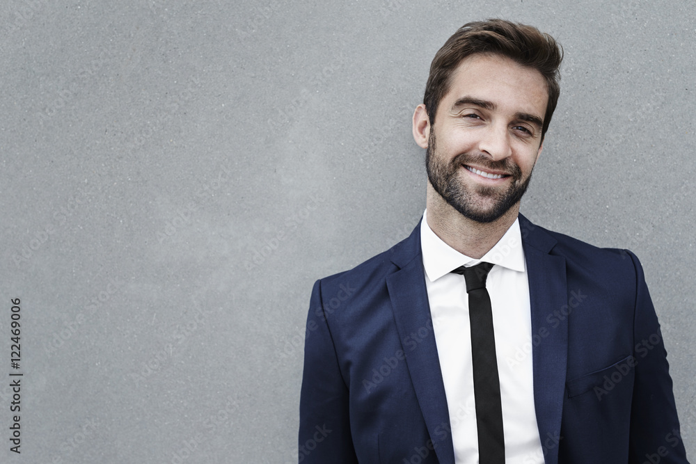 Suited businessman smiling at camera, portrait Suited businessman smiling at camera, portrait