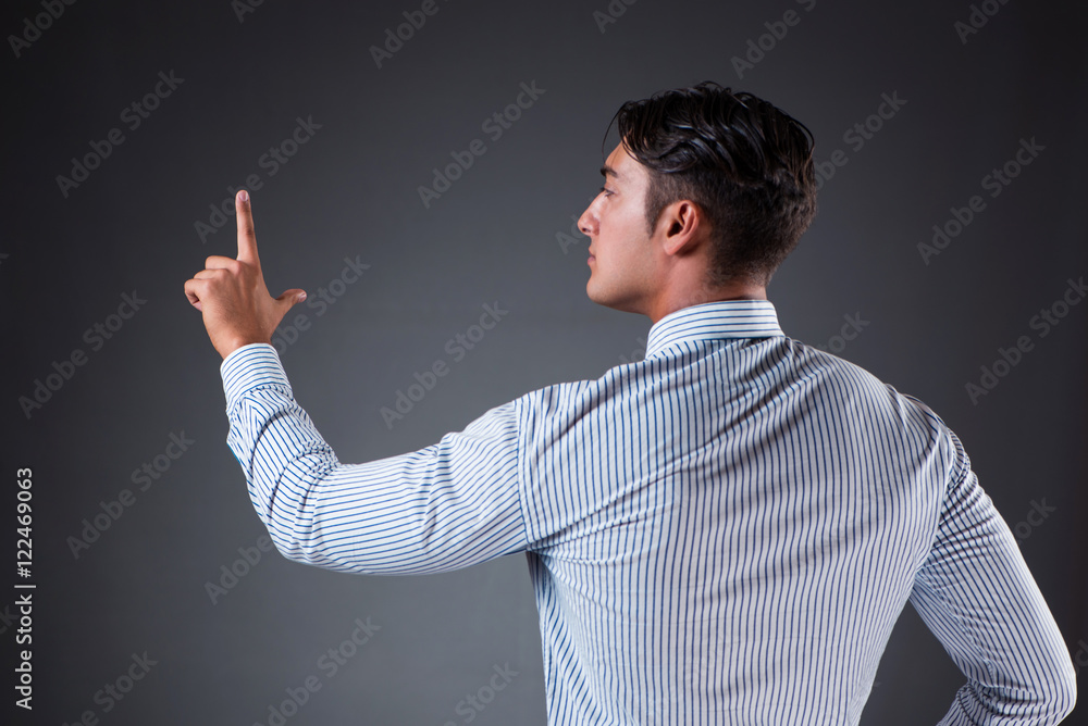 Handsome businessman pressing virtual buttons Handsome businessman pressing virtual buttons