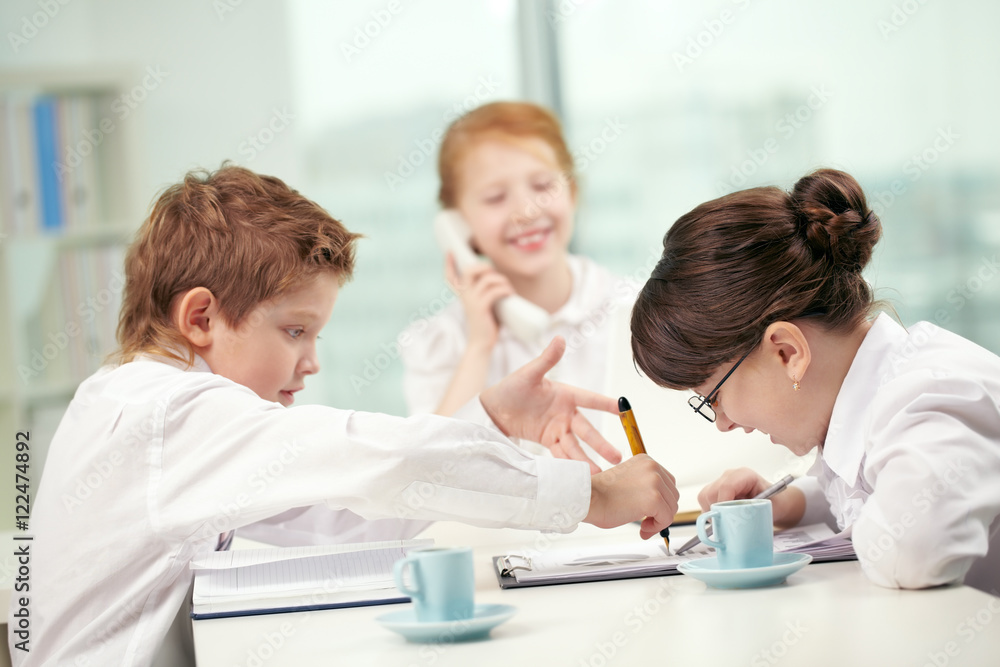 Little businessman explaining something ardently to his colleague Little businessman explaining something ardently to his colleague