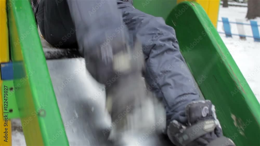 Children slide down the winter/school boy in winter down to the bottom of the slide Children Children slide down the winter/school boy in winter down to the bottom of the slide Children