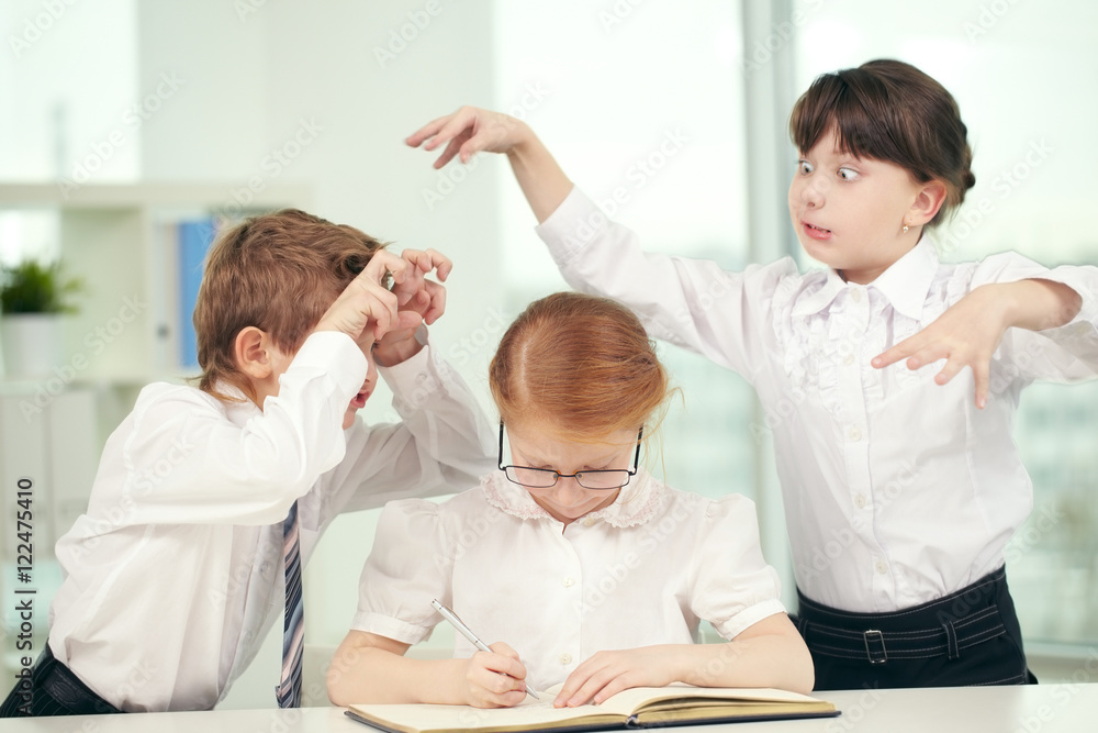 Two schoolchildren teasing a typical girl nerd Two schoolchildren teasing a typical girl nerd
