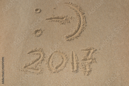 Digits 2017 on the sand seashore - concept of new year