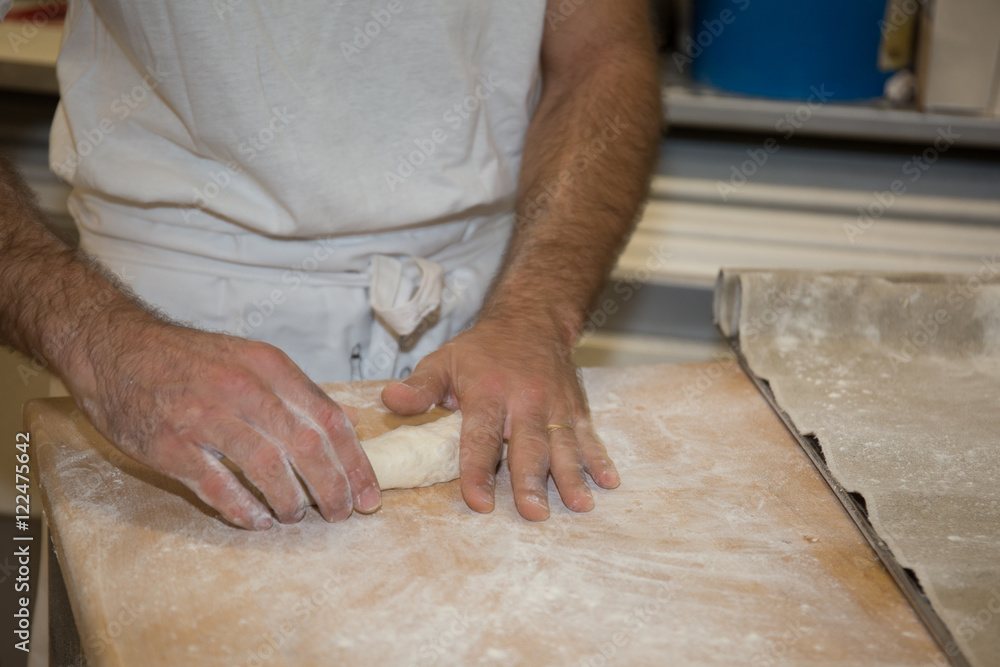 baker making bread , man hands , kneading a dough , cooking coat