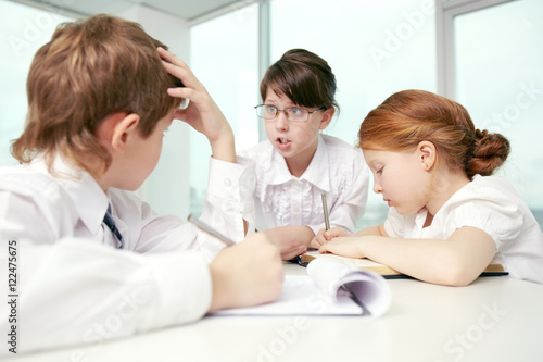 Three little children debating in classroom