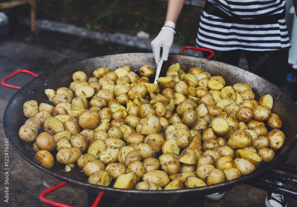 Roasted potatoes cooked in metal cauldron pot Roasted potatoes cooked in metal cauldron pot