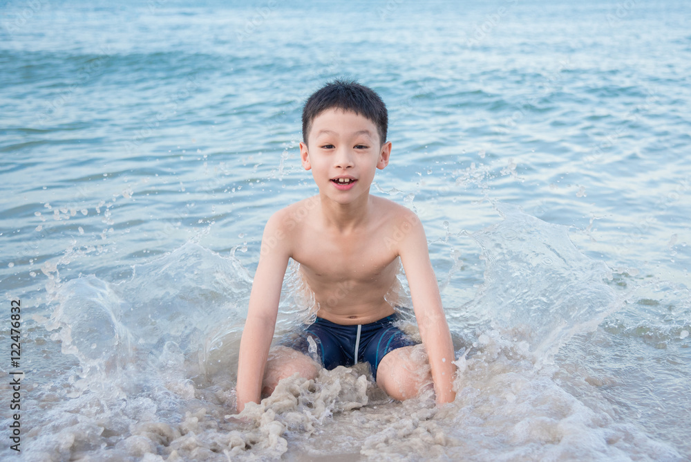 Fototapeta premium Young asian boy playing on the beach