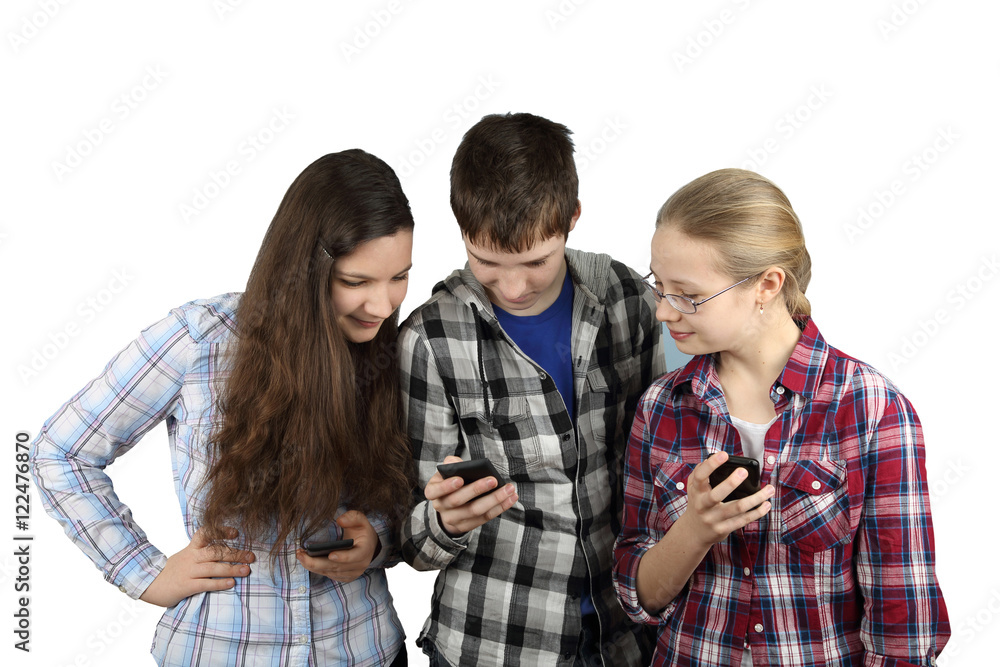 Modern gadgets, internet and communication concept - Two teenage girls and boy look at smartphone isolated on white background - Social network and entertainment Modern gadgets, internet and communication concept - Two teenage girls and boy look at smartphone isolated on white background - Social network and entertainment