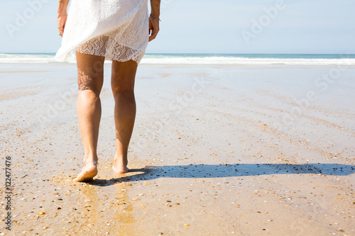 Female leg walking on the beach in the ocean.