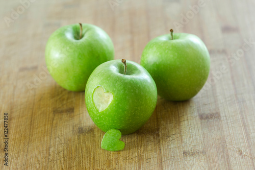 Manzana en mesa de madera con un corazon (concepto de dieta y salud) 