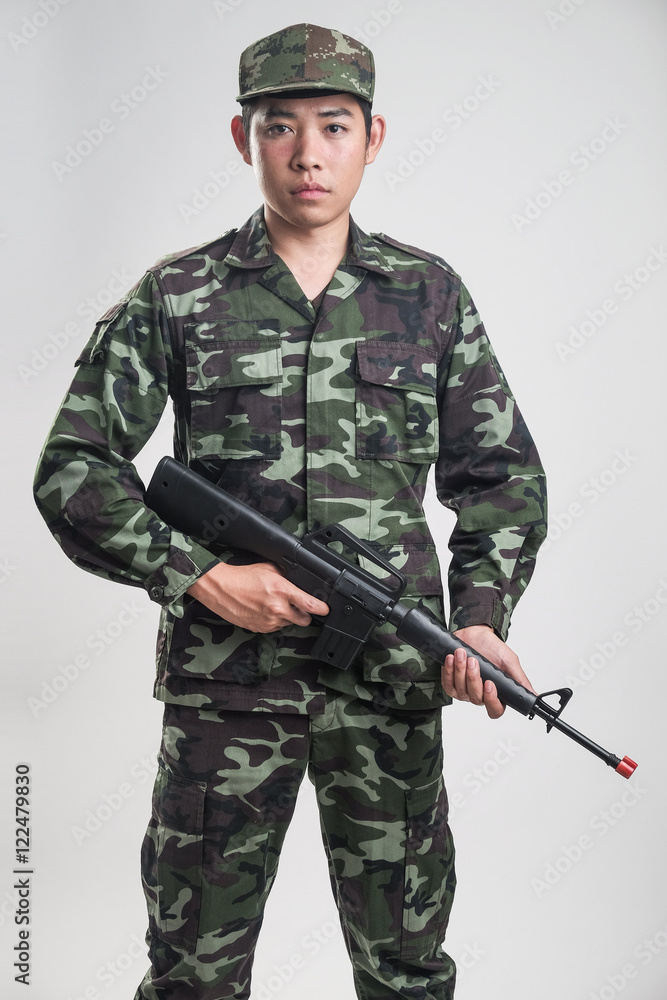 Asian soldier in green camouflage uniform with long gun Asian soldier in green camouflage uniform with long gun