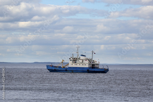 Small cargo ship on Ladoga lake under cloudy sky in northern Russia