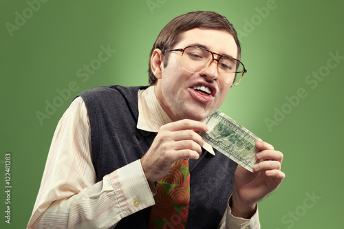 Portrait of nerd fool touched with dollar banknote photo