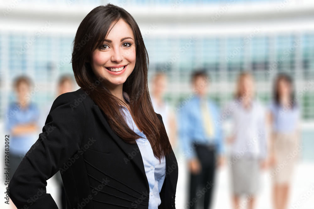 Smiling young woman in front of a group of people Smiling young woman in front of a group of people