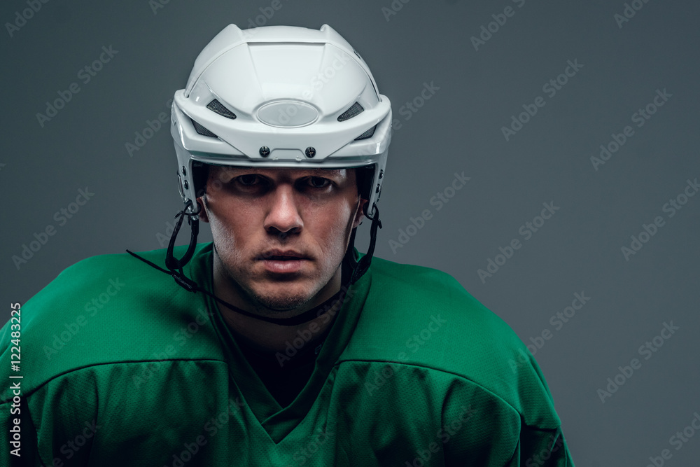 Naklejka premium Portrait of hockey player on grey background.