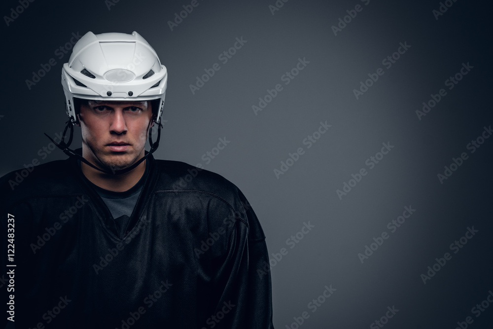 Naklejka premium Portrait of hockey player on grey background.