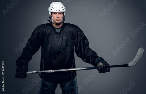 Hockey player holds gaming stick.