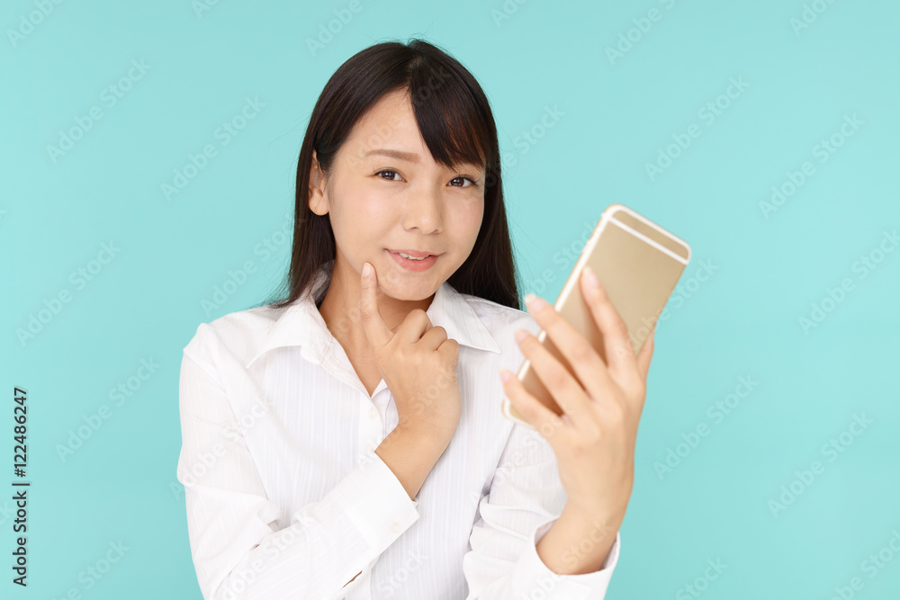 スマートフォンを持つ笑顔の女性