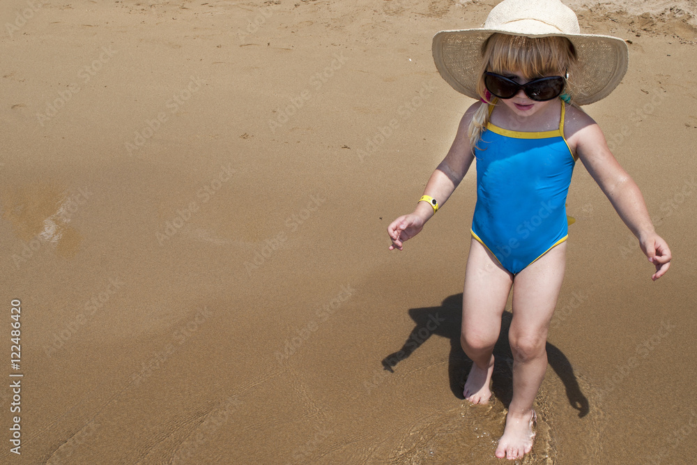 Cute happy baby girl wearing swimming suit, sun glasses, hat Stock