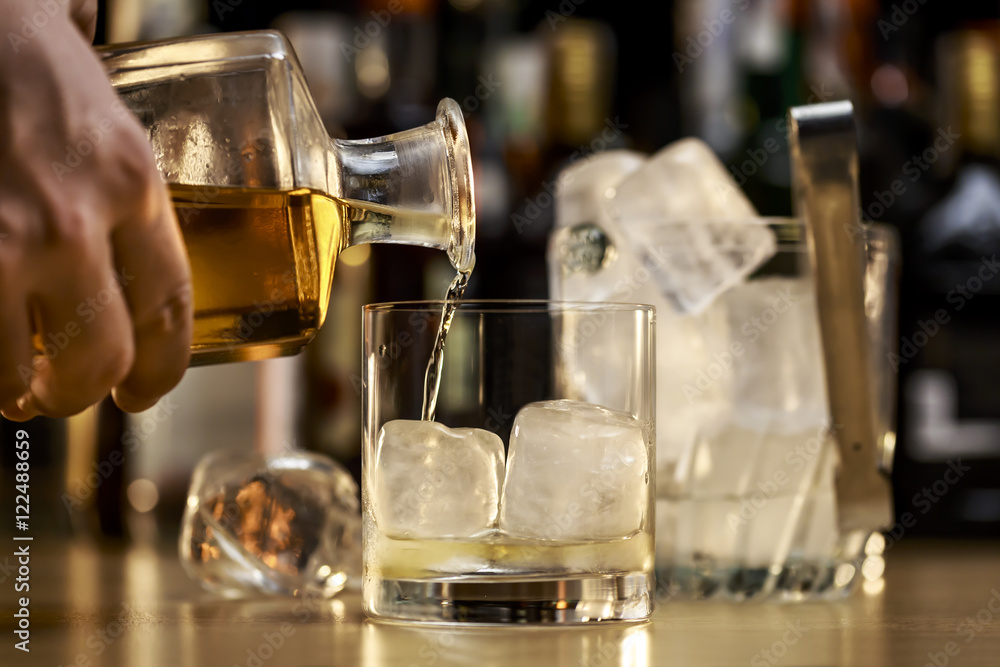 Barman is serving a good whiskey on the rocks Barman is serving a good whiskey on the rocks