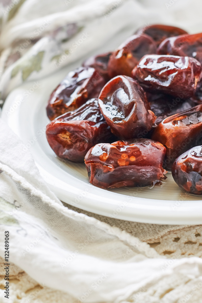 Dried dates fruit in white plate. Copy space Dried dates fruit in white plate. Copy space