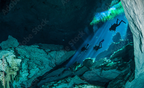 Canvas Print Divers descending into the waters of a cenote on the west coast of mexico's Yuca
