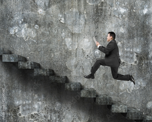 Man using tablet running on old dirty concrete stairs