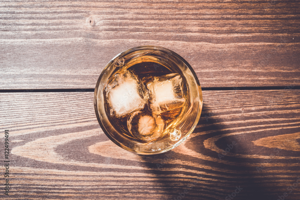 Glass of whiskey on an old wooden table