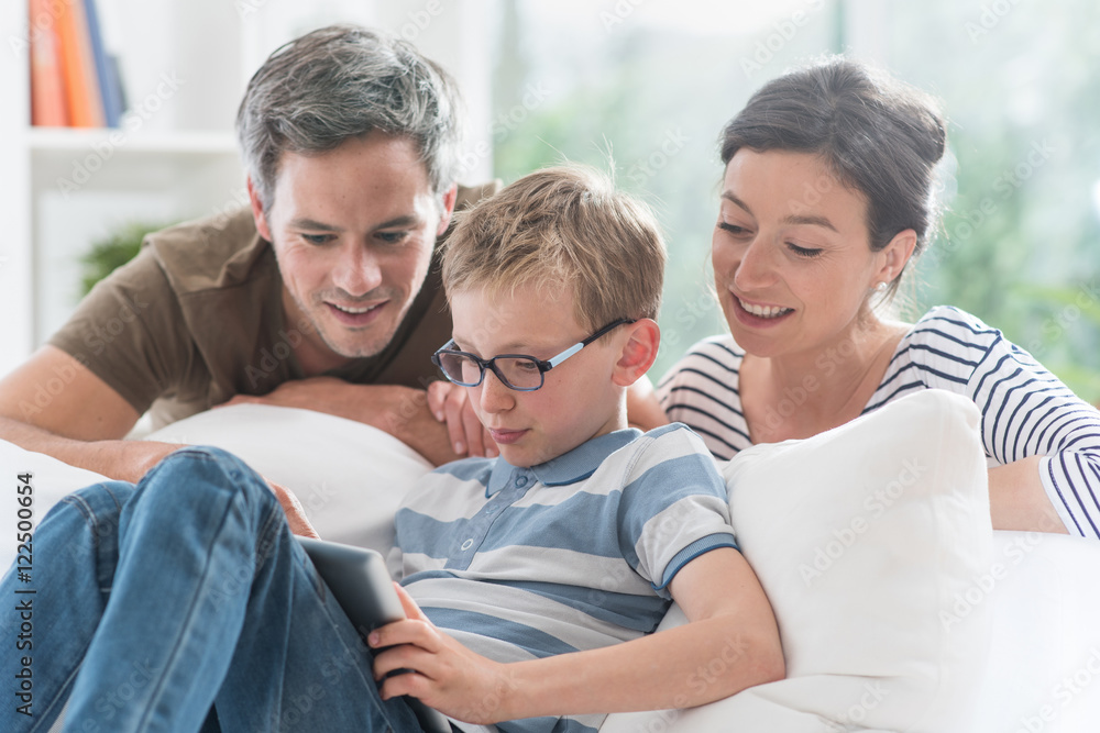 a cheerful family has fun together by playing on a tablet a cheerful family has fun together by playing on a tablet