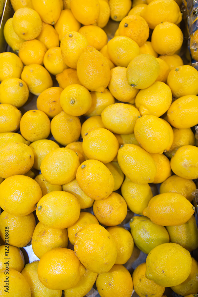 Lot of bright yellow lemons in supermarket