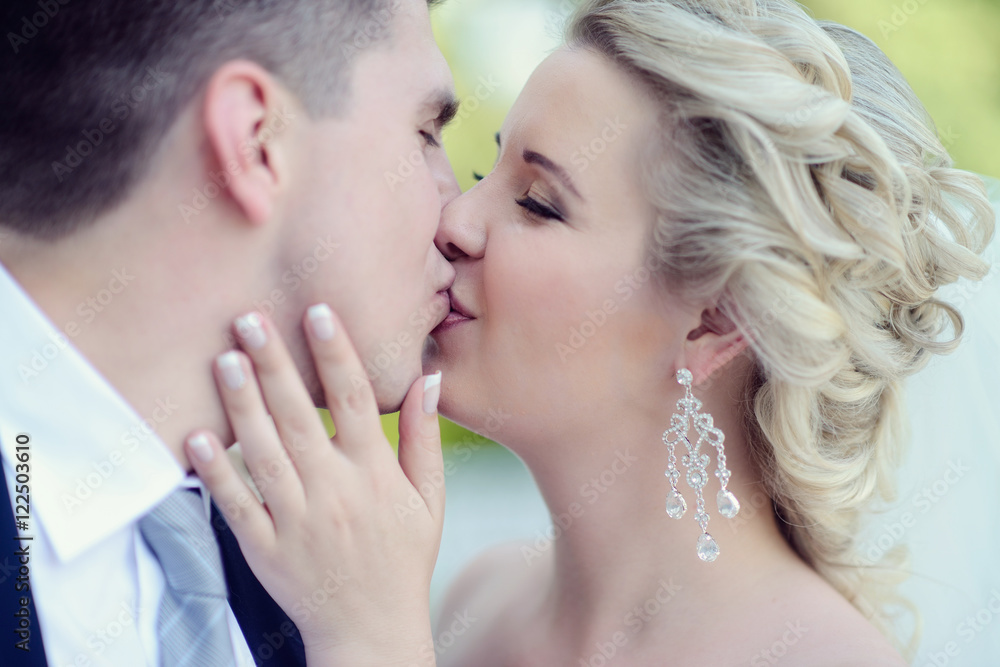 Wedding couple on the nature is hugging each other. Beautiful model girl in white dress. Man in suit. Beauty bride with groom. Female and male portrait. Woman with lace veil. Lady and guy outdoors Wedding couple on the nature is hugging each other. Beautiful model girl in white dress. Man in suit. Beauty bride with groom. Female and male portrait. Woman with lace veil. Lady and guy outdoors