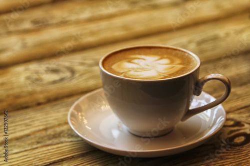 cup of coffee cappuccino on wooden table . Soft focus vintage picture