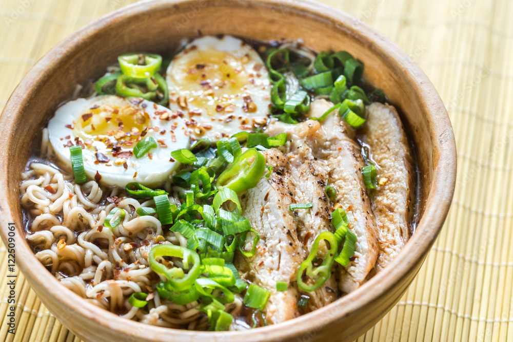 Bowl of chicken ramen soup on the wooden table