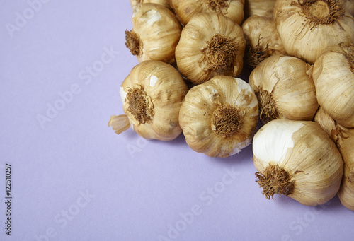 Garlic bulbs arranged on a pale purple background