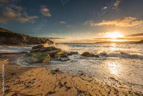 Waves crashing on the rocks at sunset