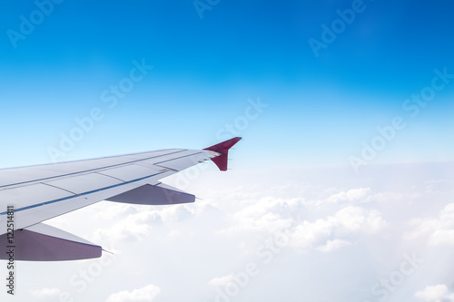 Aerial view of cloud and sky and land with airplane wing from ai