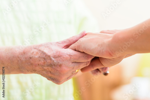 Altenpfleger hält Hand von Seniorin © Kzenon