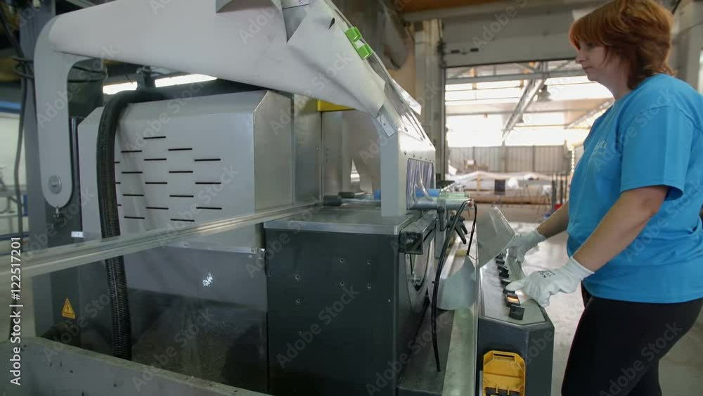 A woman who is working in the factory is regulating a machine. She is pressing a few buttons. She is wearing protective gloves. Wide-angle shot.
A woman who is working in the factory is regulating a machine. She is pressing a few buttons. She is wearing protective gloves. Wide-angle shot.