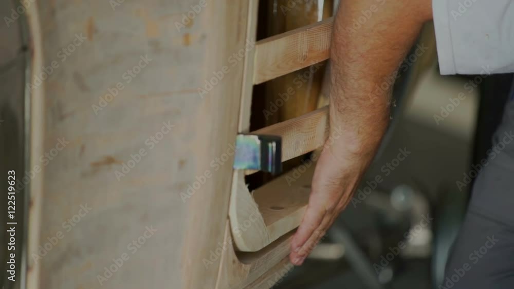 A joiner is gently touching the bottom part of the door in the car. He is checking if they are even. Close-up shot.
A joiner is gently touching the bottom part of the door in the car. He is checking if they are even. Close-up shot.