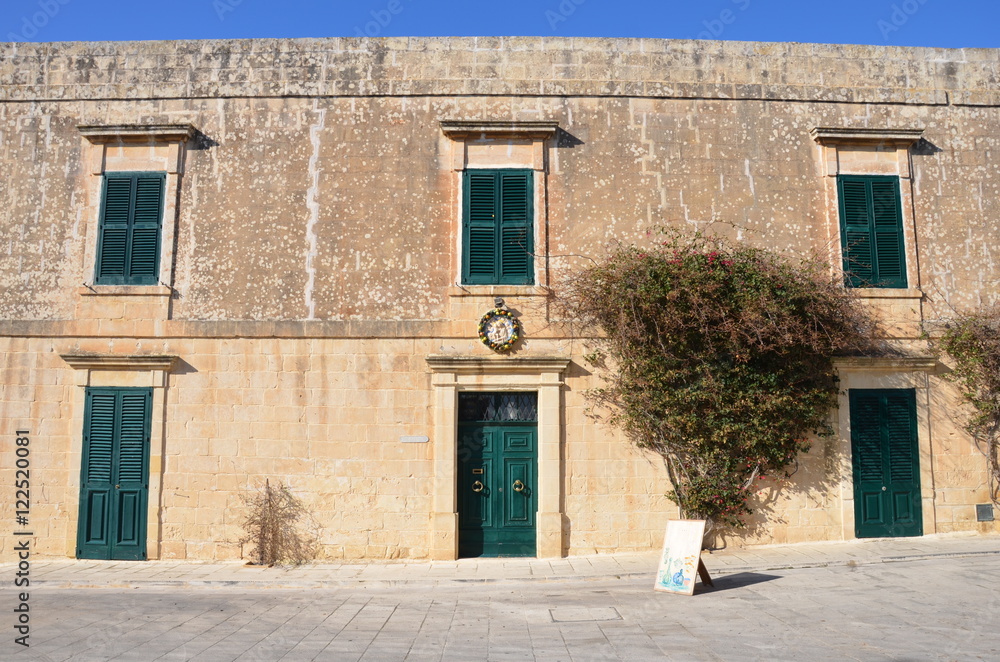 Old house in Malta with green windows