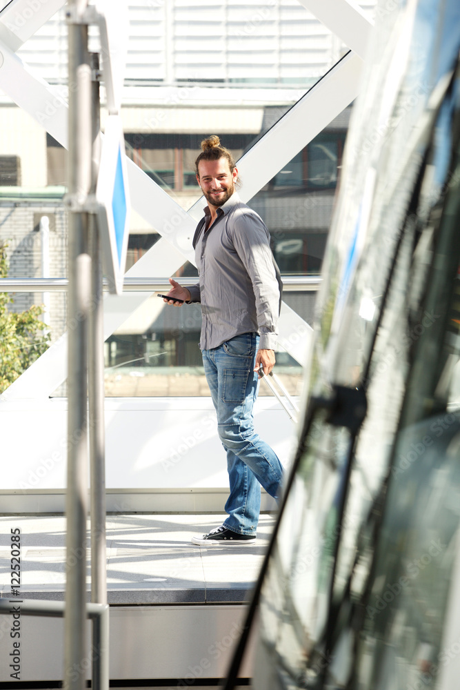 Man walking with luggage and mobile phone Man walking with luggage and mobile phone