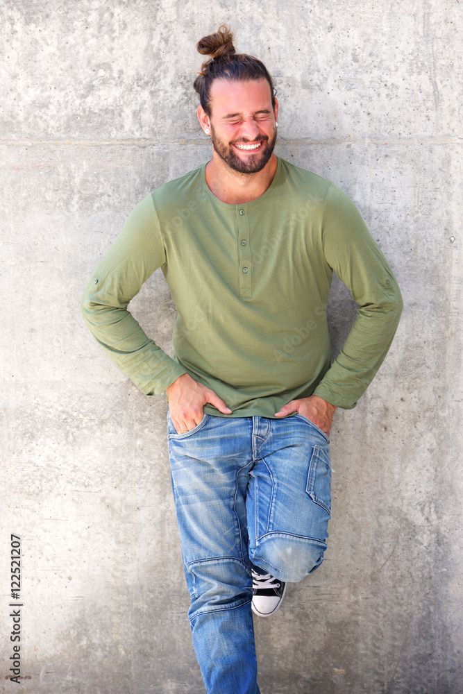 Laughing man standing with hands in pockets Laughing man standing with hands in pockets