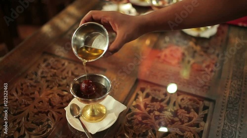 The person waters the dessert honey in restaurant photo