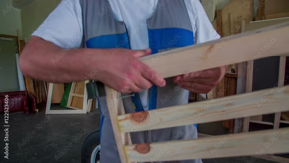A man is bringing the door of the wooden car and he is putting them together. Wide-angle shot. He is working in his workshop at home.
A man is bringing the door of the wooden car and he is putting them together. Wide-angle shot. He is working in his workshop at home.