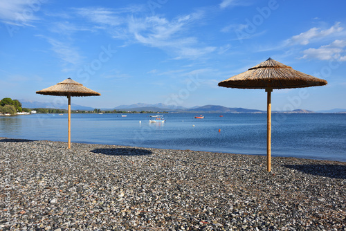 Fototapeta Naklejka Na Ścianę i Meble -  Pebble beach and parasols in Greece